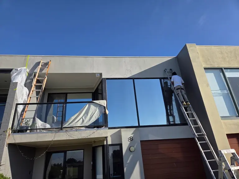 Painter working on a two-storey exterior repaint